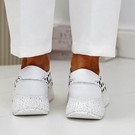 Tył stóp w artikerach – buty sneakersy z wyraźnie teksturowaną piętą i kontrastową podeszwą