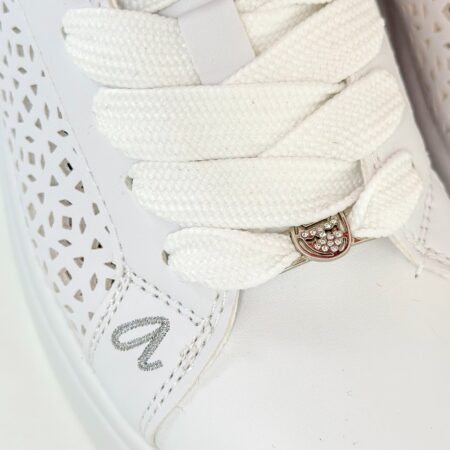 Zbliżenie na noski sneakersów Anekke – haftowane logo „a” i ozdobny detal przy sznurówkach – ażurowe sneakersy